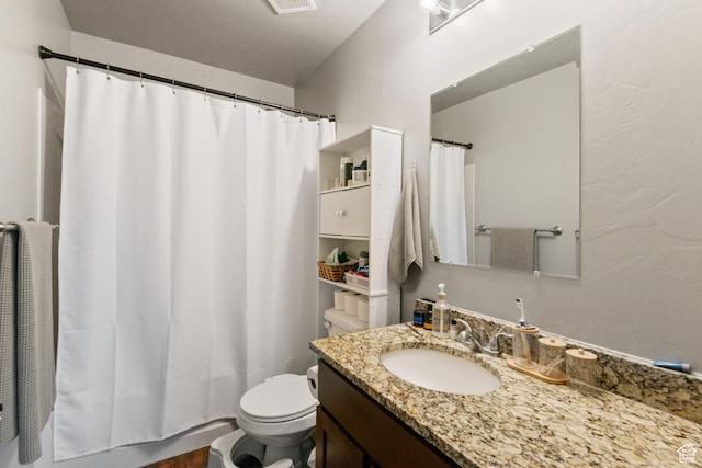 bathroom with a shower with curtain, vanity, toilet, a textured wall, and visible vents
