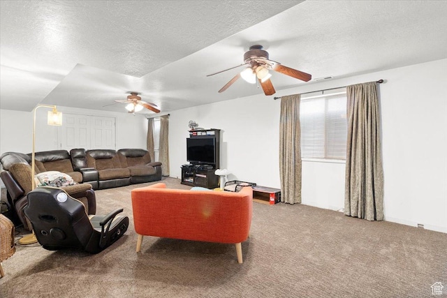 carpeted living room with visible vents, ceiling fan, and a textured ceiling