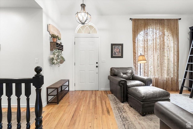 foyer featuring plenty of natural light, light wood-style floors, and a chandelier