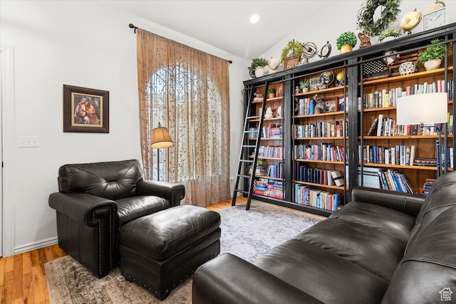 sitting room featuring baseboards, lofted ceiling, and wood finished floors