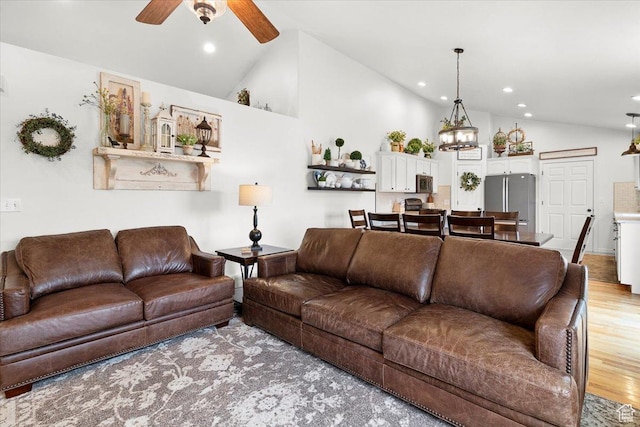 living room featuring a ceiling fan, high vaulted ceiling, light wood finished floors, and recessed lighting