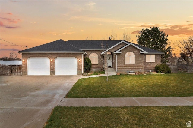 single story home with concrete driveway, fence, an attached garage, brick siding, and a front lawn