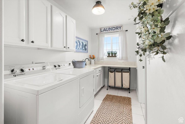 clothes washing area featuring light tile patterned floors, a sink, cabinet space, and washer and dryer