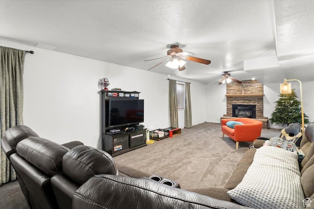 carpeted living area featuring a textured ceiling, a ceiling fan, and a stone fireplace