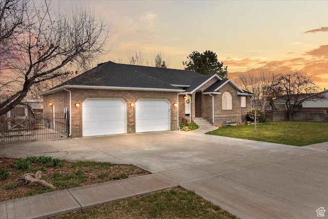 ranch-style home with driveway, a garage, brick siding, and a yard
