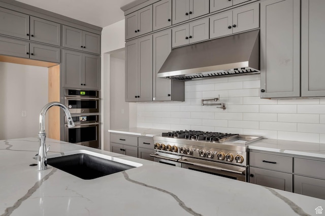 14913 S Thorntree Ln, Herriman, UT 84096 - kitchen with under cabinet range hood, gray cabinets, stainless steel appliances, and a sink