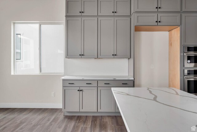 14913 S Thorntree Ln, Herriman, UT 84096 - kitchen with gray cabinets, light wood-style floors, and light stone countertops