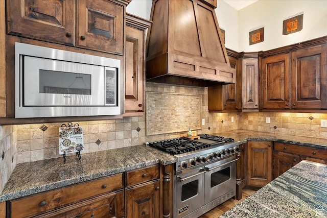 1049 S Meadow Lark Ln E, Huntsville, UT 84317 - kitchen featuring stainless steel appliances, dark stone counters, custom range hood, and decorative backsplash