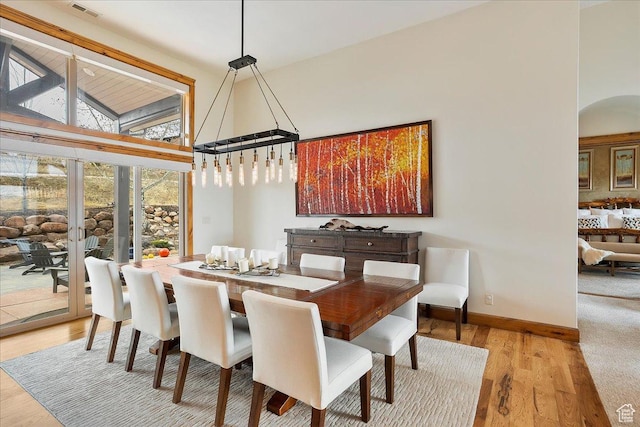 1049 S Meadow Lark Ln E, Huntsville, UT 84317 - dining space featuring high vaulted ceiling, arched walkways, wood finished floors, and baseboards