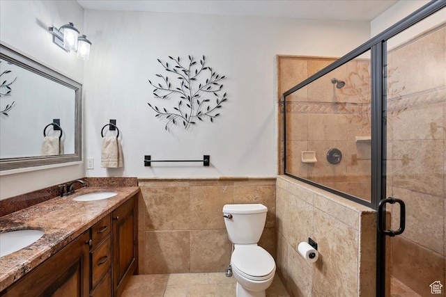 1049 S Meadow Lark Ln E, Huntsville, UT 84317 - bathroom with double vanity, tile walls, a shower stall, toilet, and a wainscoted wall