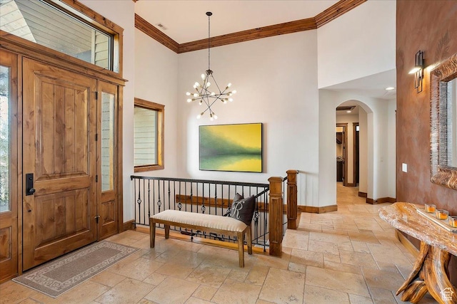1049 S Meadow Lark Ln E, Huntsville, UT 84317 - entrance foyer with stone tile flooring, a high ceiling, baseboards, crown molding, and arched walkways