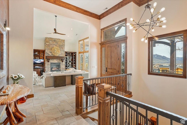 1049 S Meadow Lark Ln E, Huntsville, UT 84317 - entryway with stone tile flooring, a fireplace, a chandelier, crown molding, and a ceiling fan