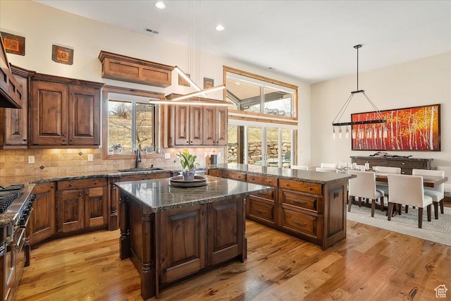 1049 S Meadow Lark Ln E, Huntsville, UT 84317 - kitchen with a center island, a sink, tasteful backsplash, dark stone countertops, and recessed lighting