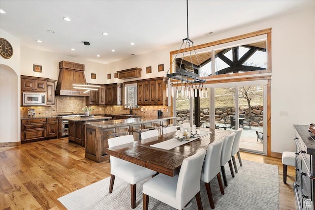 1049 S Meadow Lark Ln E, Huntsville, UT 84317 - dining room with arched walkways, recessed lighting, light wood finished floors, and a towering ceiling