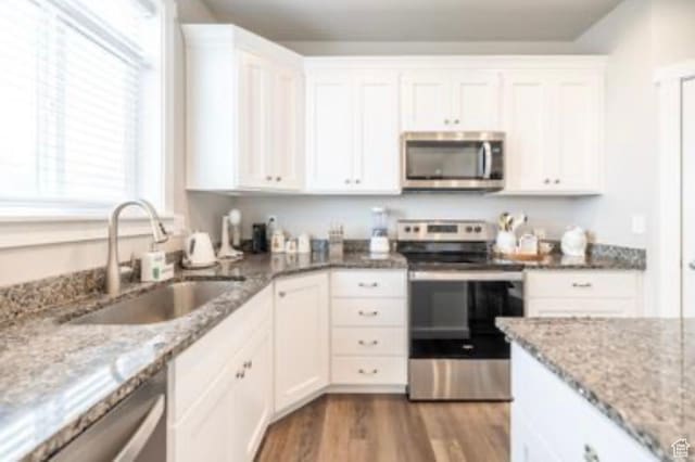 910 N 260 W, Santaquin, UT 84655 - kitchen featuring appliances with stainless steel finishes, white cabinetry, a sink, light stone counters, and dark wood-style floors