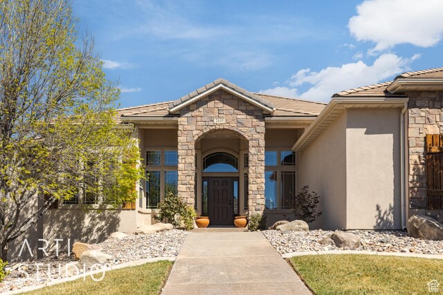 2445 E 2860 S, St George, UT 84790 - view of exterior entry with stone siding, a tiled roof, and stucco siding