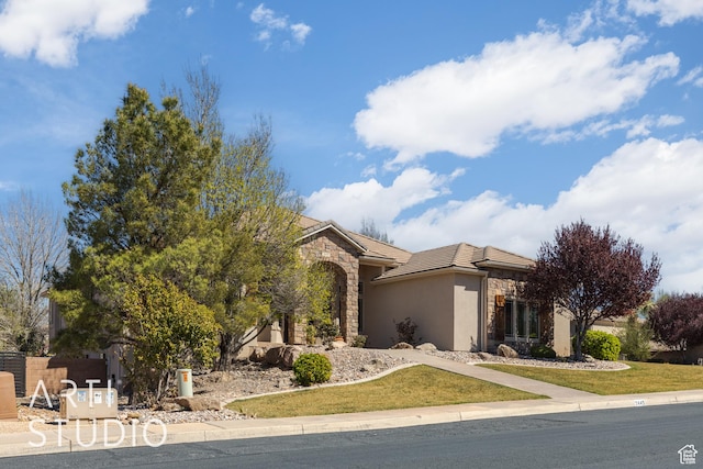 2445 E 2860 S, St George, UT 84790 - view of front facade featuring stone siding, a tiled roof, a front yard, and stucco siding