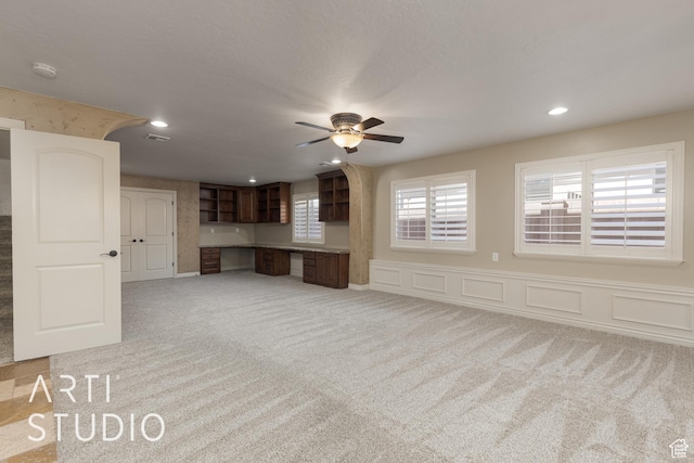 2445 E 2860 S, St George, UT 84790 - unfurnished living room with built in desk, recessed lighting, ceiling fan, light carpet, and wainscoting