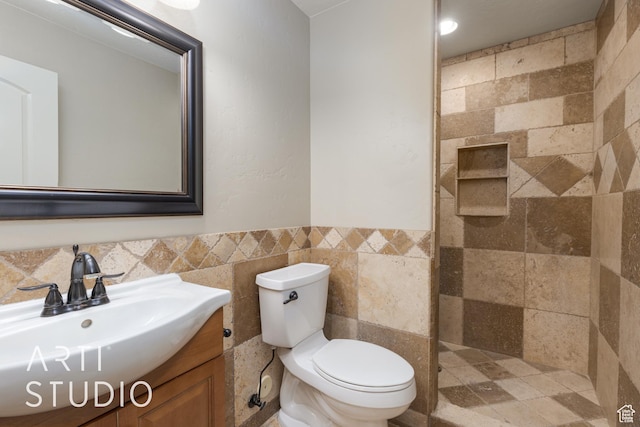 2445 E 2860 S, St George, UT 84790 - bathroom featuring vanity, a tile shower, tile walls, toilet, and wainscoting