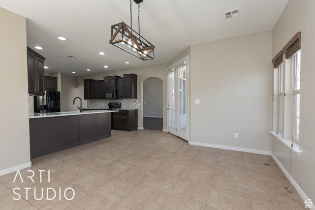 2445 E 2860 S, St George, UT 84790 - kitchen with light countertops, tasteful backsplash, baseboards, arched walkways, and black appliances