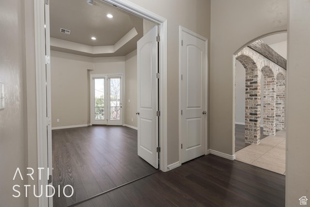 2445 E 2860 S, St George, UT 84790 - hallway featuring dark wood finished floors, baseboards, arched walkways, and a tray ceiling