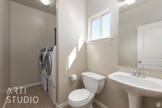 2445 E 2860 S, St George, UT 84790 - half bathroom featuring a sink, baseboards, toilet, and separate washer and dryer