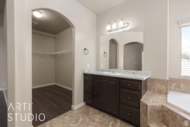 2445 E 2860 S, St George, UT 84790 - full bathroom with baseboards, a garden tub, a walk in closet, and vanity