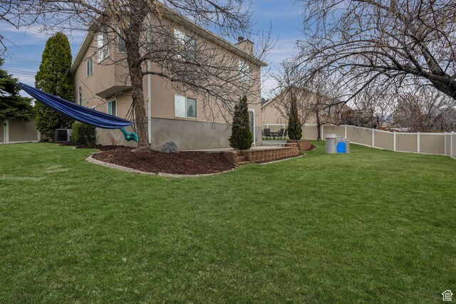 view of yard with cooling unit and fence