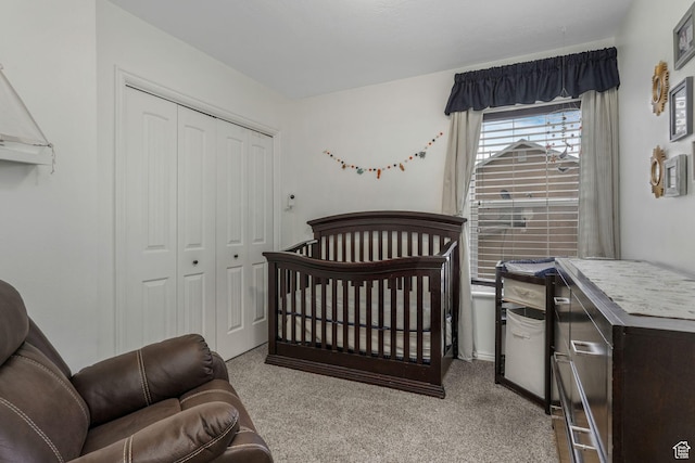 carpeted bedroom featuring a nursery area and a closet