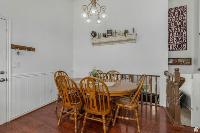 dining room featuring wood finished floors, an inviting chandelier, and wainscoting