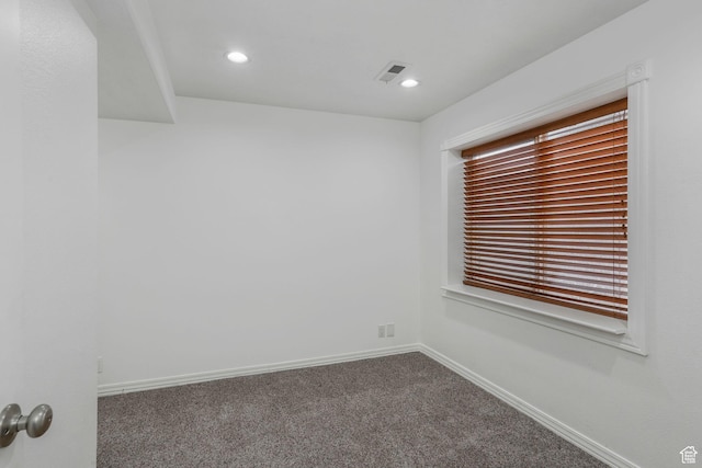 carpeted empty room with baseboards, visible vents, and recessed lighting