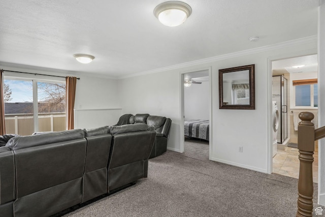 living room with baseboards, stacked washer / dryer, crown molding, and light carpet