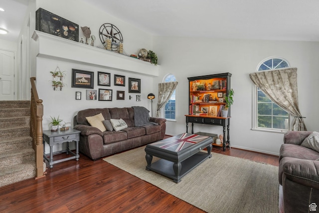 living room featuring lofted ceiling, wood finished floors, and stairway