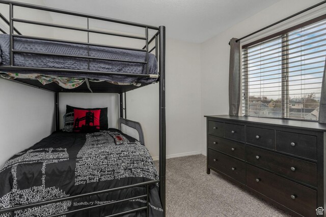 bedroom featuring light carpet and baseboards