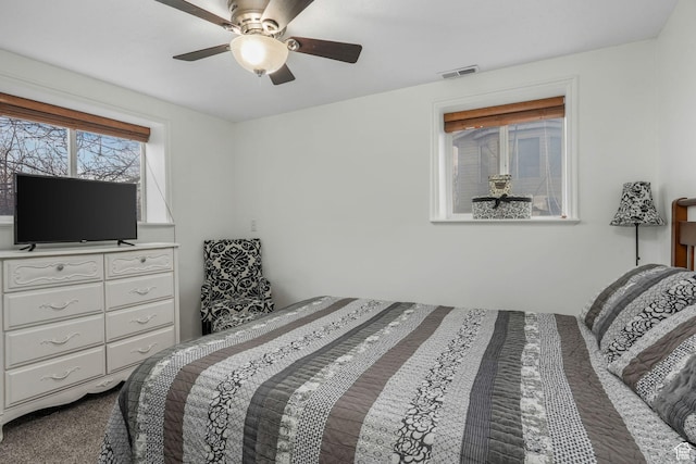 carpeted bedroom with ceiling fan and visible vents