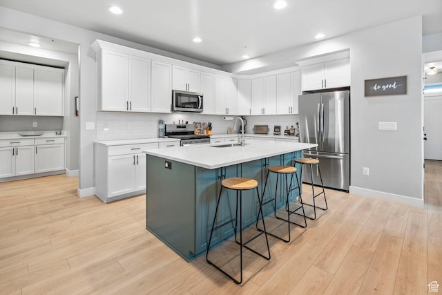3161 N 3150 W, Plain City, UT 84404 - kitchen with light countertops, a sink, white cabinetry, light wood-style flooring, and stainless steel appliances