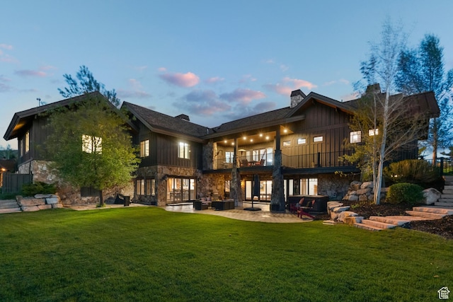 7507 Sage Meadow Rd, Park City, UT 84098 - back of property with a balcony, stone siding, a lawn, and a patio area