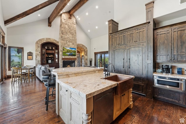 7507 Sage Meadow Rd, Park City, UT 84098 - kitchen featuring high vaulted ceiling, a stone fireplace, beam ceiling, dark wood-style floors, and healthy amount of natural light