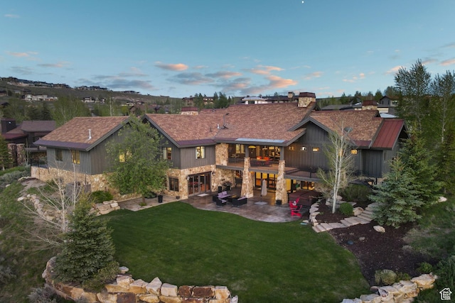 7507 Sage Meadow Rd, Park City, UT 84098 - rear view of house featuring a patio, stone siding, and a lawn