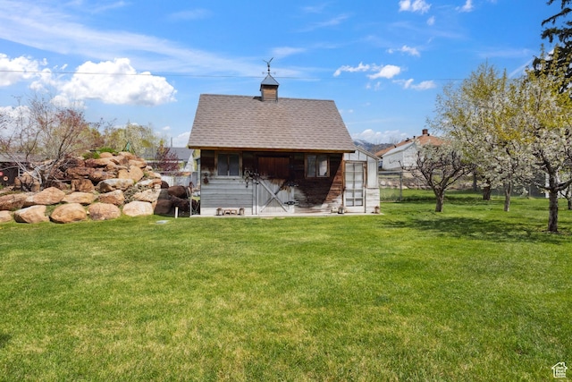 368 E 300 N, Logan, UT 84321 - back of house featuring a chimney, an outbuilding, a yard, and roof with shingles