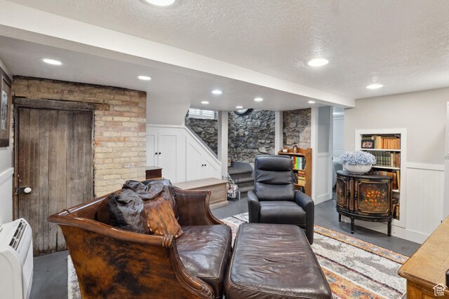 368 E 300 N, Logan, UT 84321 - living area with stairs, a decorative wall, wainscoting, concrete flooring, and a textured ceiling