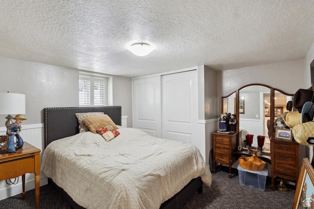 368 E 300 N, Logan, UT 84321 - bedroom with dark carpet, a closet, wainscoting, and a textured ceiling