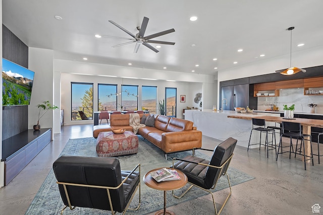 living area with finished concrete flooring, recessed lighting, and a ceiling fan