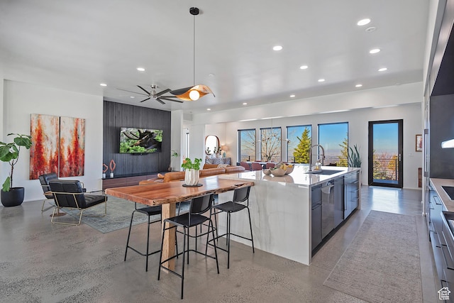 kitchen with modern cabinets, recessed lighting, a sink, open floor plan, and concrete flooring