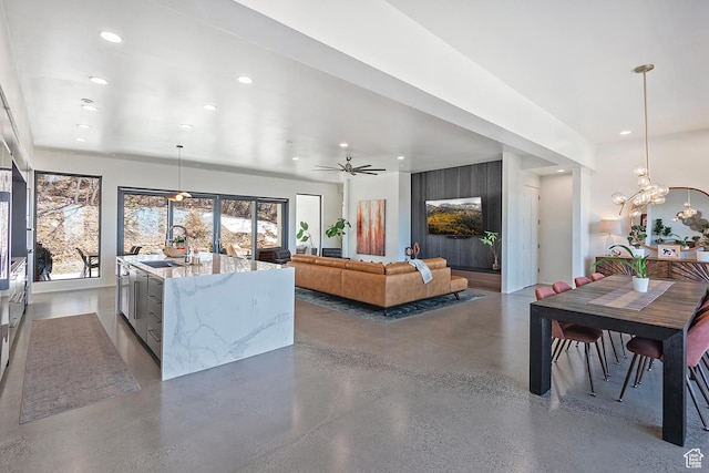 living area featuring concrete floors, an inviting chandelier, and recessed lighting