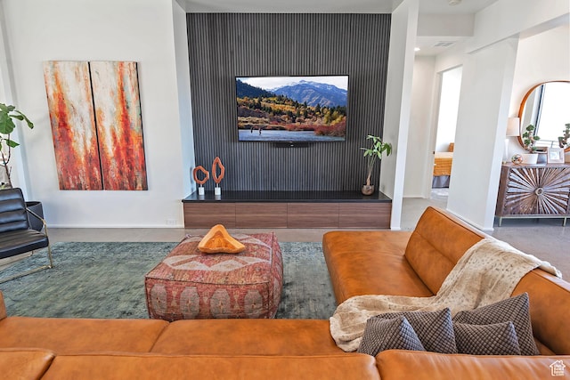 living area with baseboards and visible vents