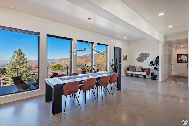dining space with concrete floors, baseboards, a mountain view, and recessed lighting