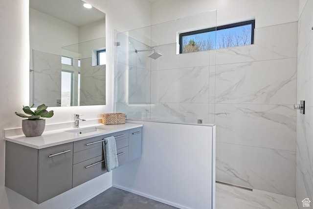 bathroom with a marble finish shower and vanity
