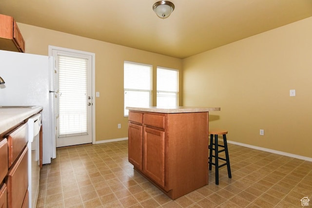 202 E Aparicio Dr, Tooele, UT 84074 - kitchen with a kitchen breakfast bar, light countertops, a kitchen island, and brown cabinetry