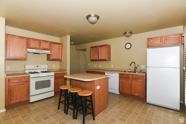 202 E Aparicio Dr, Tooele, UT 84074 - kitchen featuring light countertops, white appliances, a kitchen island, under cabinet range hood, and a sink